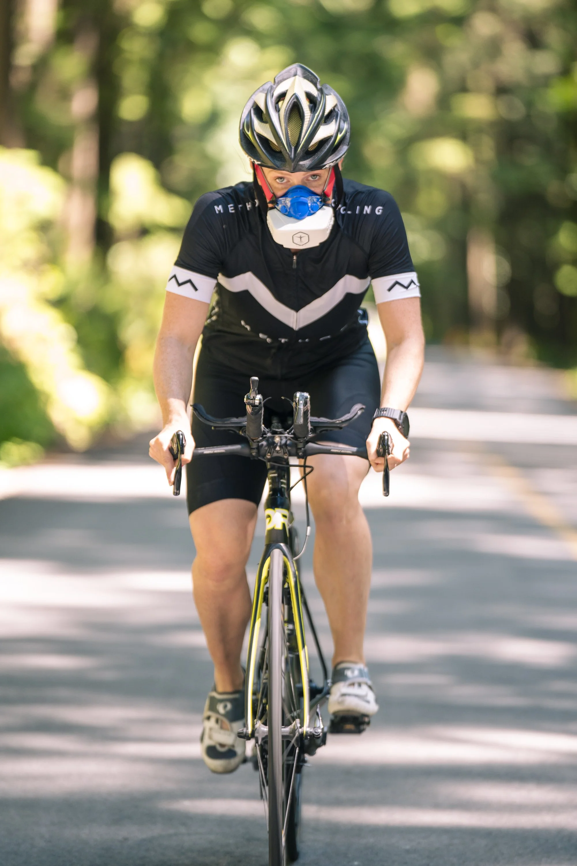 Athlete performing a VO2 max test on a stationary bike while wearing a VO2 Master metabolic analyzer mask