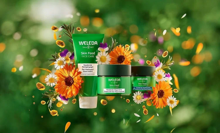 Een drietal gezichtverzorgingsproducten in groene potjes en een tube, zwevend tegen een groene achtergrond met groen en witte bloemen