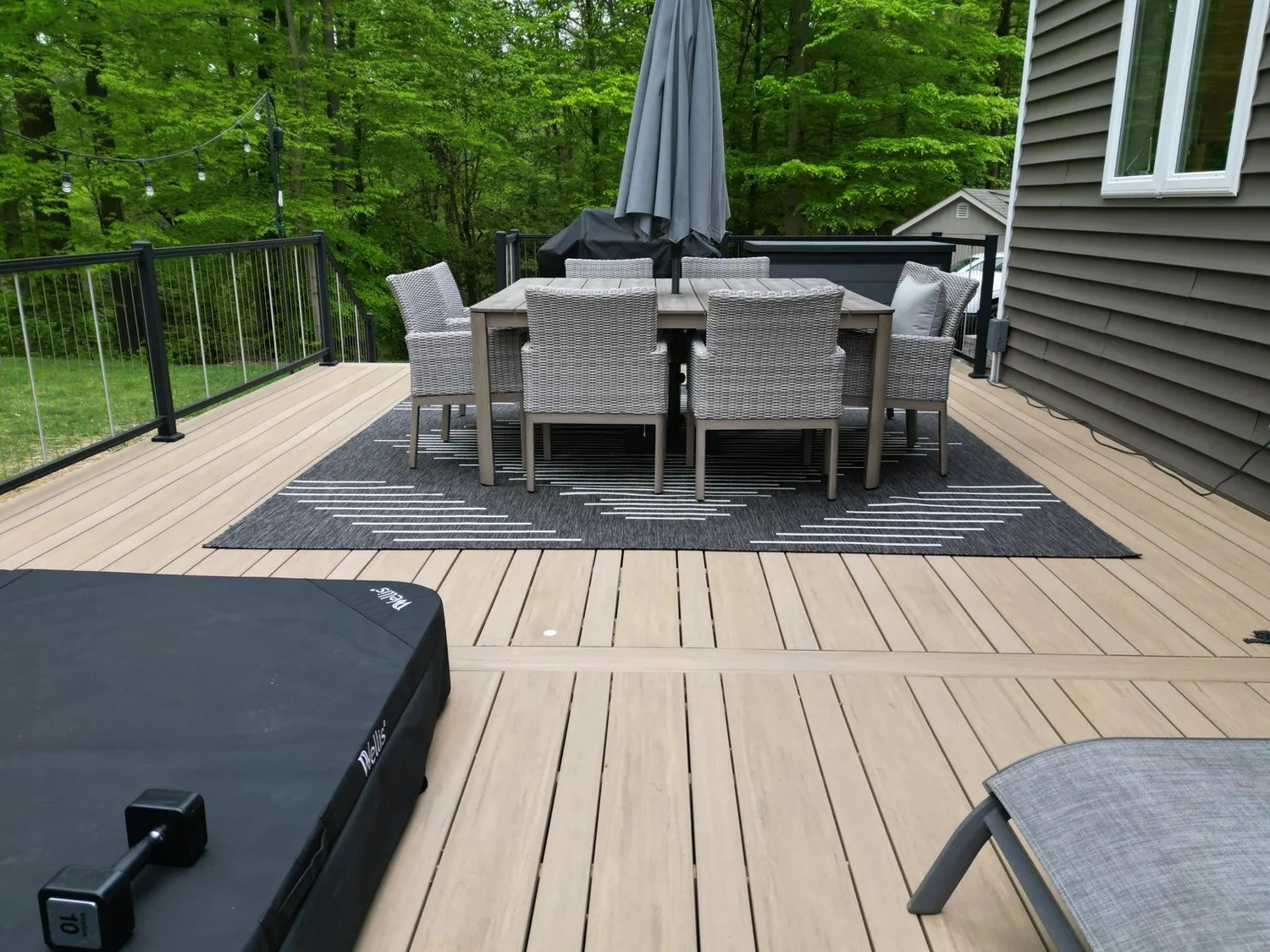 Outdoor dining table on a TimberTech deck with dark railings in Crownsville, Maryland