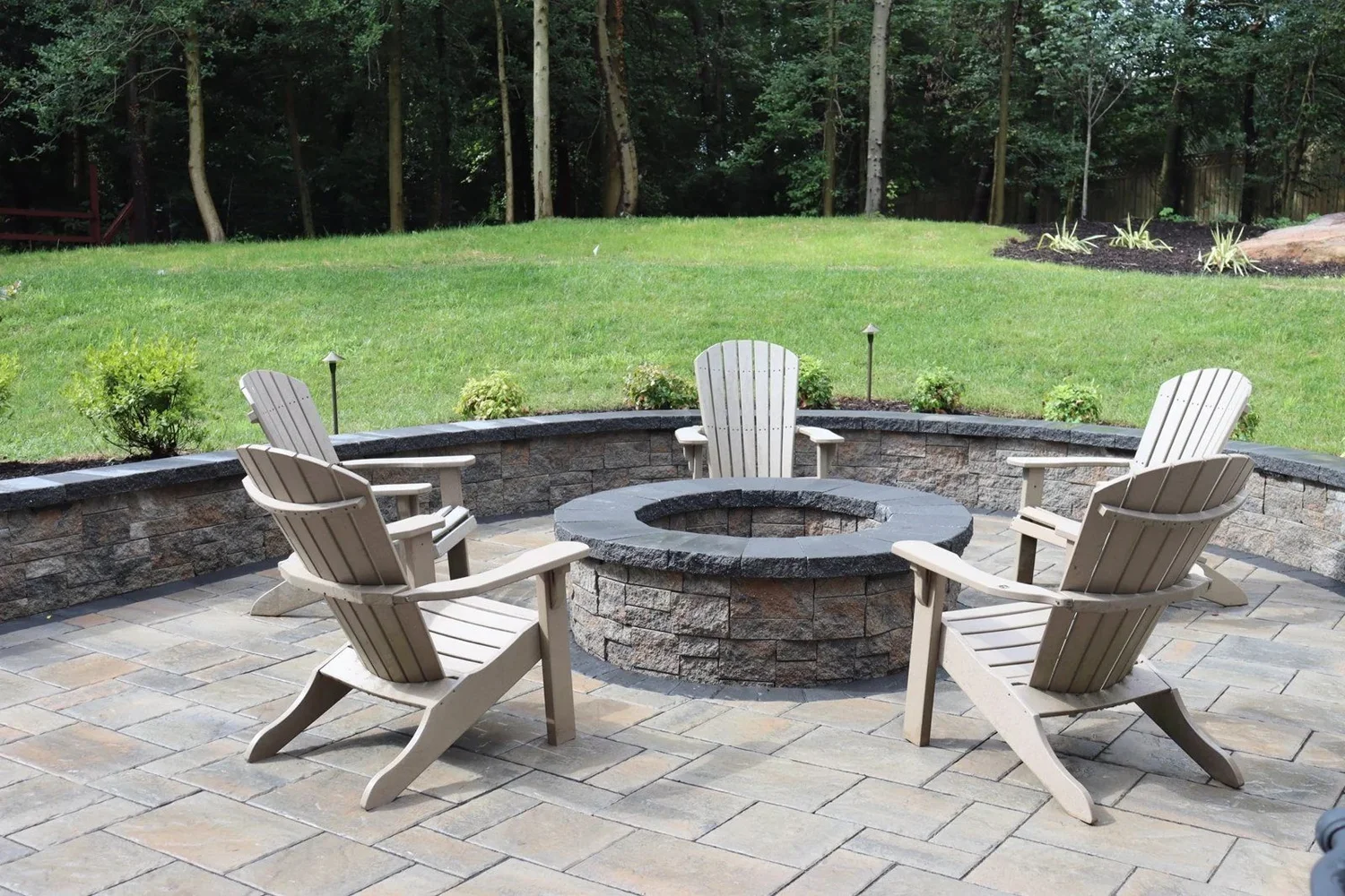 Circular firepit, Adirondack chairs and curved sitting wall on the Severna Park patio