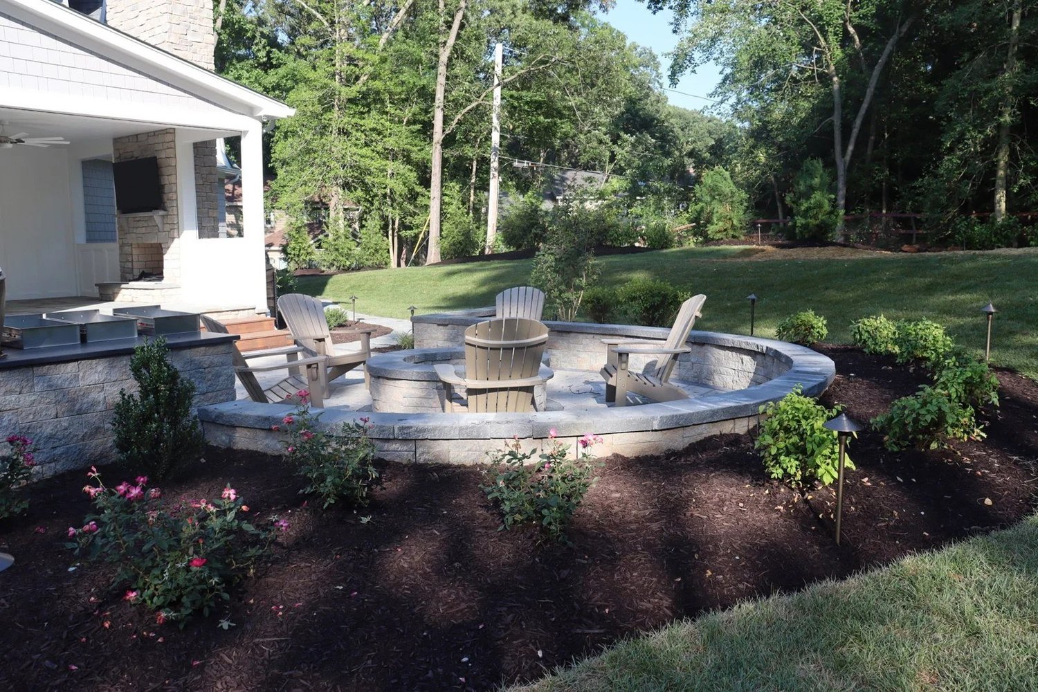 View from the garden toward the curved patio and firepit in Severna Park