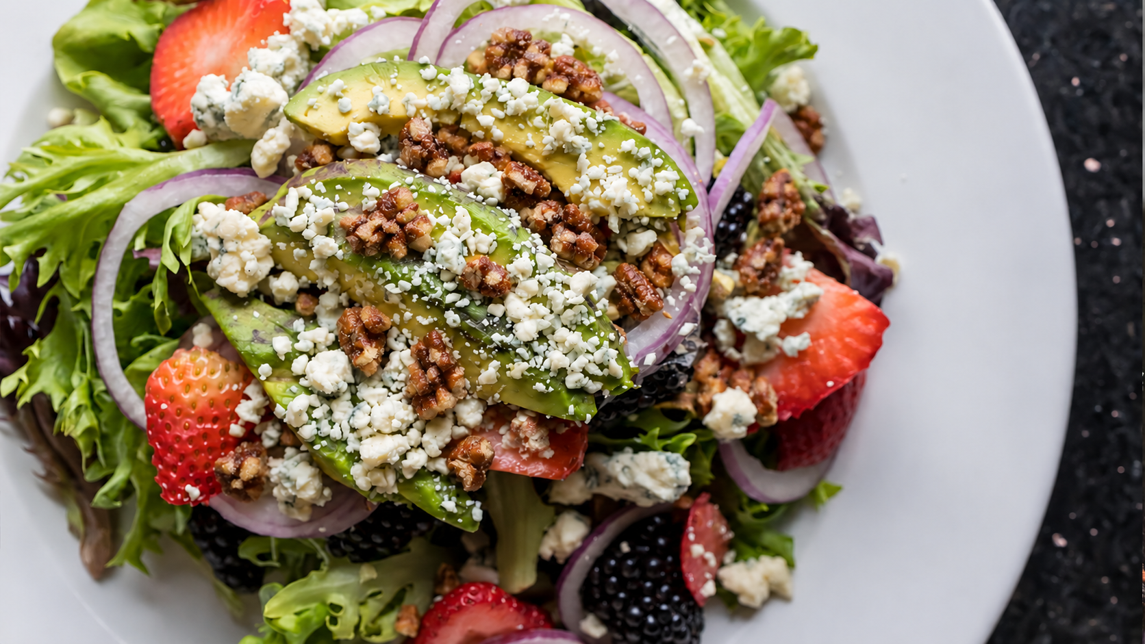 Pizza One salad with avocado, berries, crumbled cheese and chopped candied pecans
