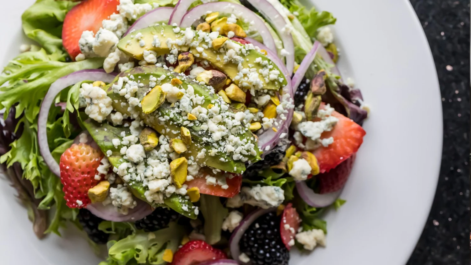 Pizza One salad with avocado, berries and crumbled cheese