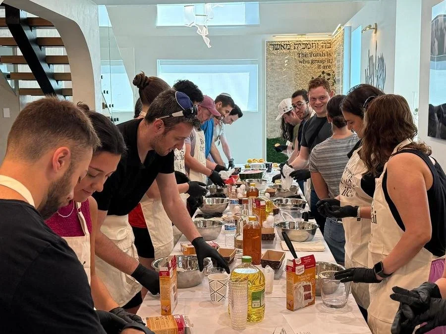 A room full of volunteers in aprons baking together