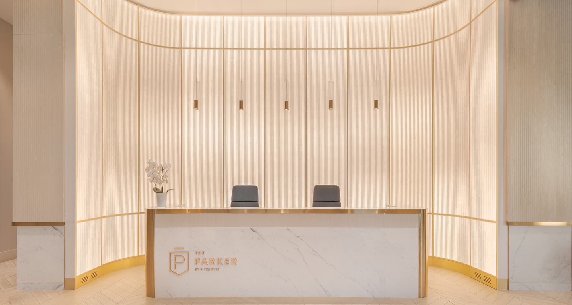 A backlit feature wall at the reception of an apartment tower, depicting a linear design that goes from the floor to the ceiling.