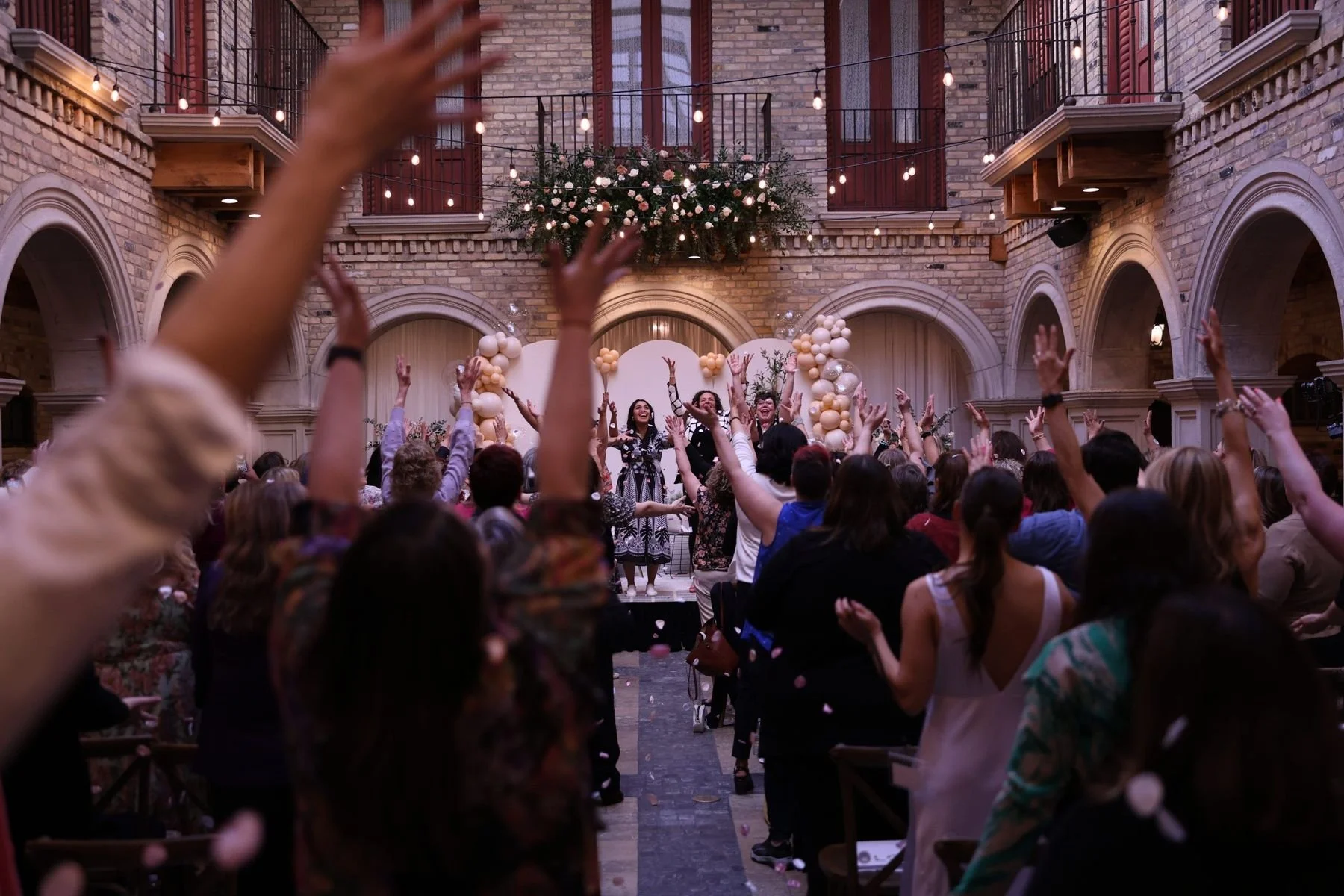 An audience with hands raised during Mariangelica's talk