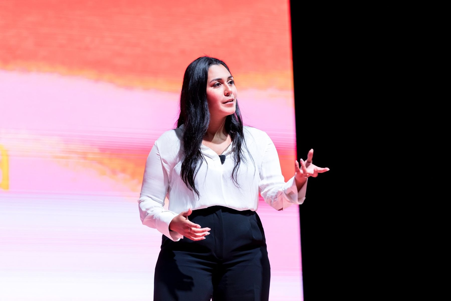Mariangelica gesturing to the audience from a stage