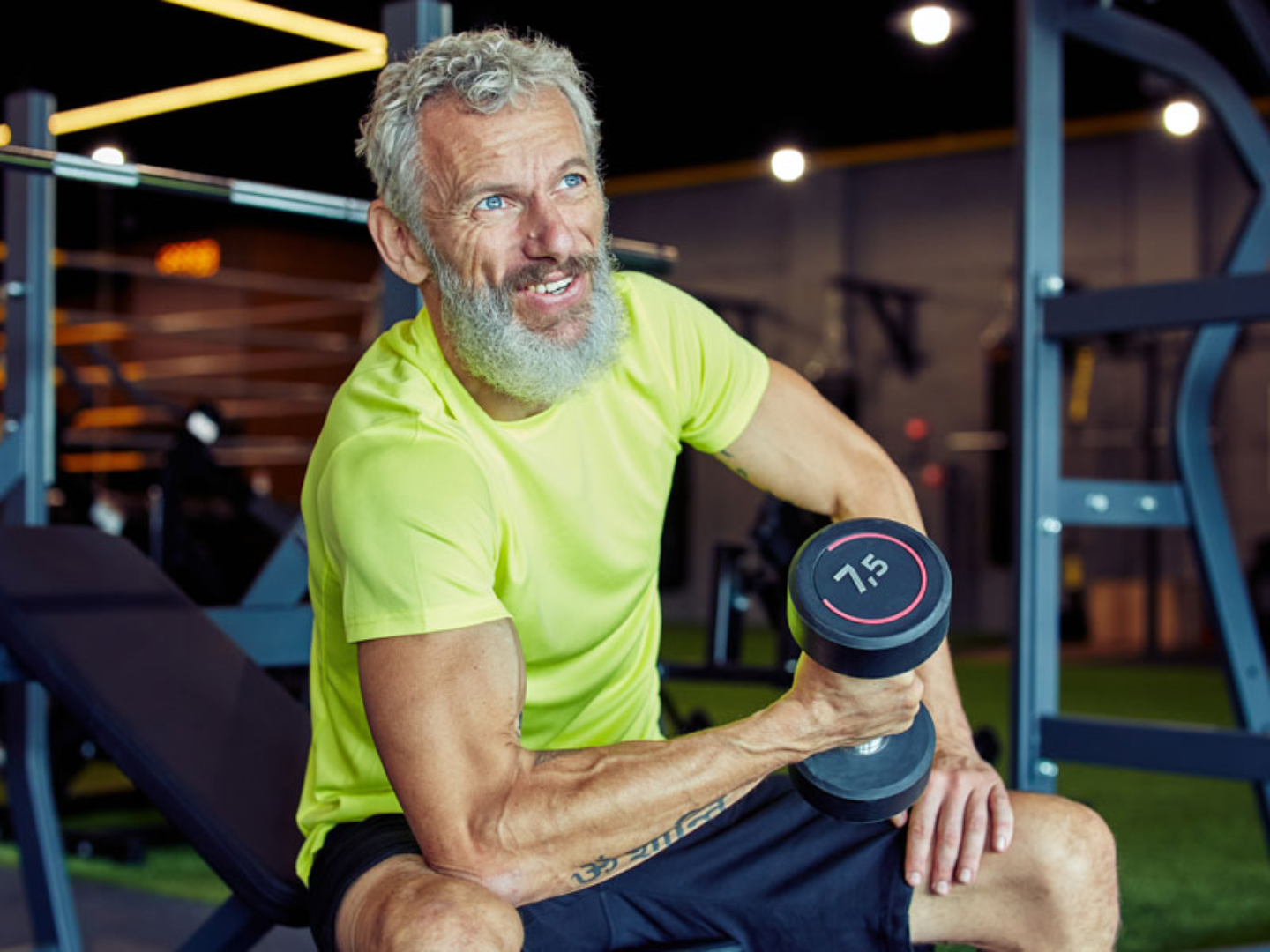 Middle-aged man lifting a dumbbell in a gym representing testosterone therapy and hormone optimization for strength and vitality