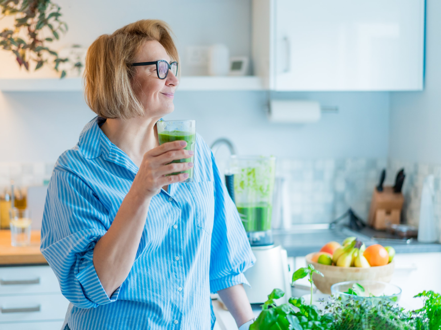 Woman drinking a green smoothie representing healthy detox lifestyle and nutritional support for natural detoxification pathways