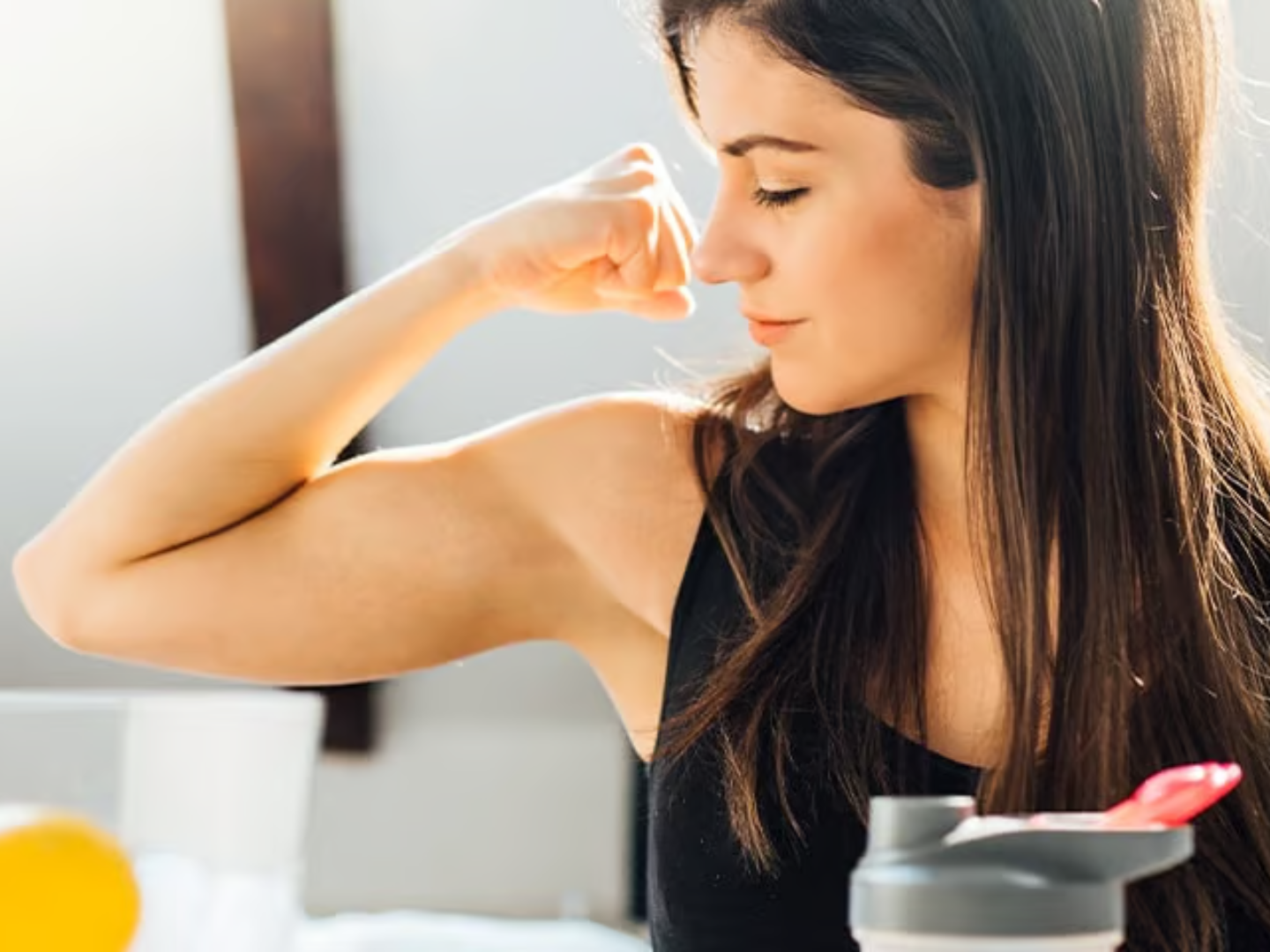 Woman showing arm muscle strength representing immune system resilience and functional medicine immune support