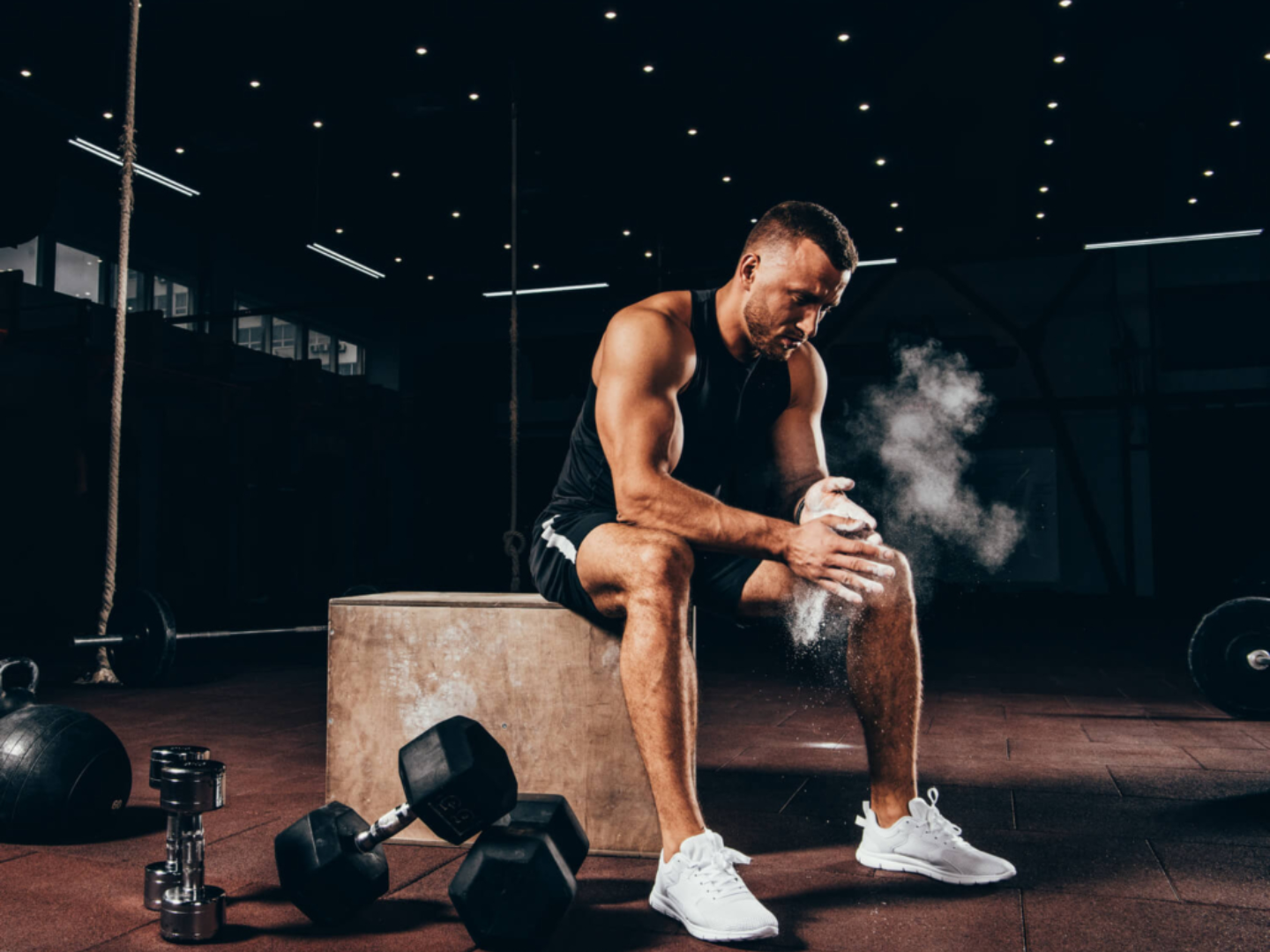 Athletic man resting after weight training representing muscle recovery and testosterone optimization for men's health