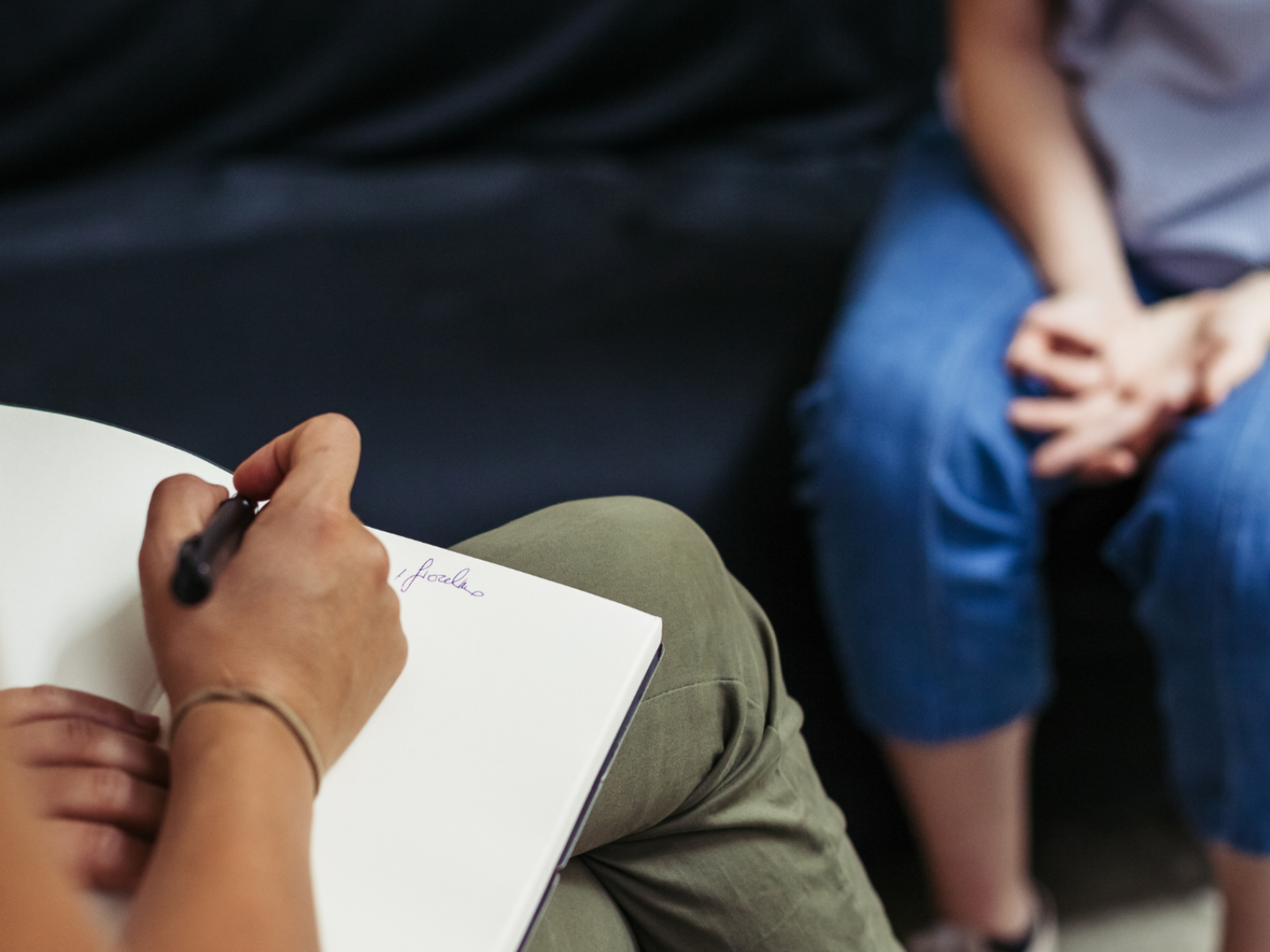 Counselor taking notes during a mental health counseling session at SageMED