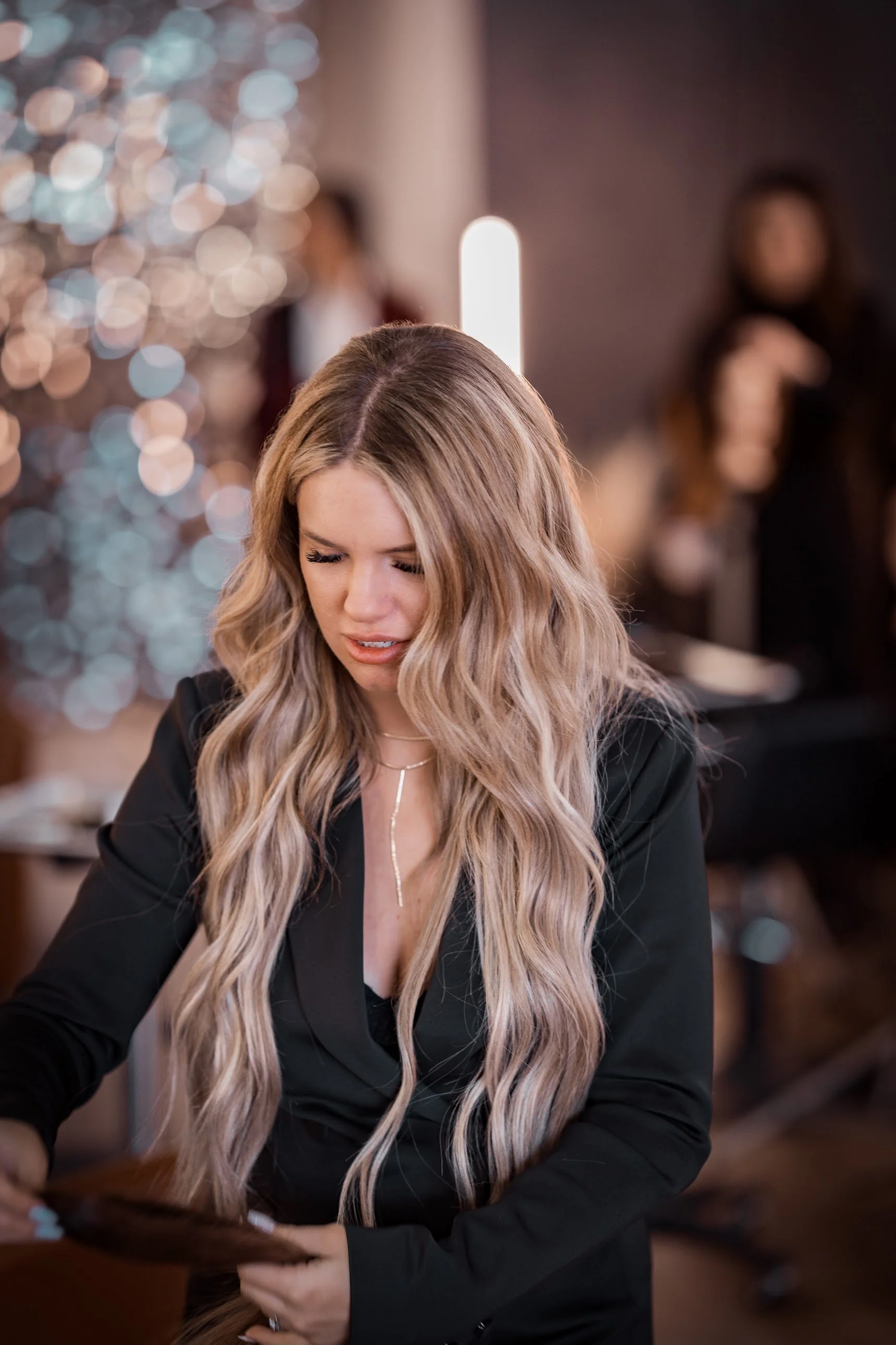 Carissa Maness holding a hair-extension bundle, a candid portrait from a recent photo session