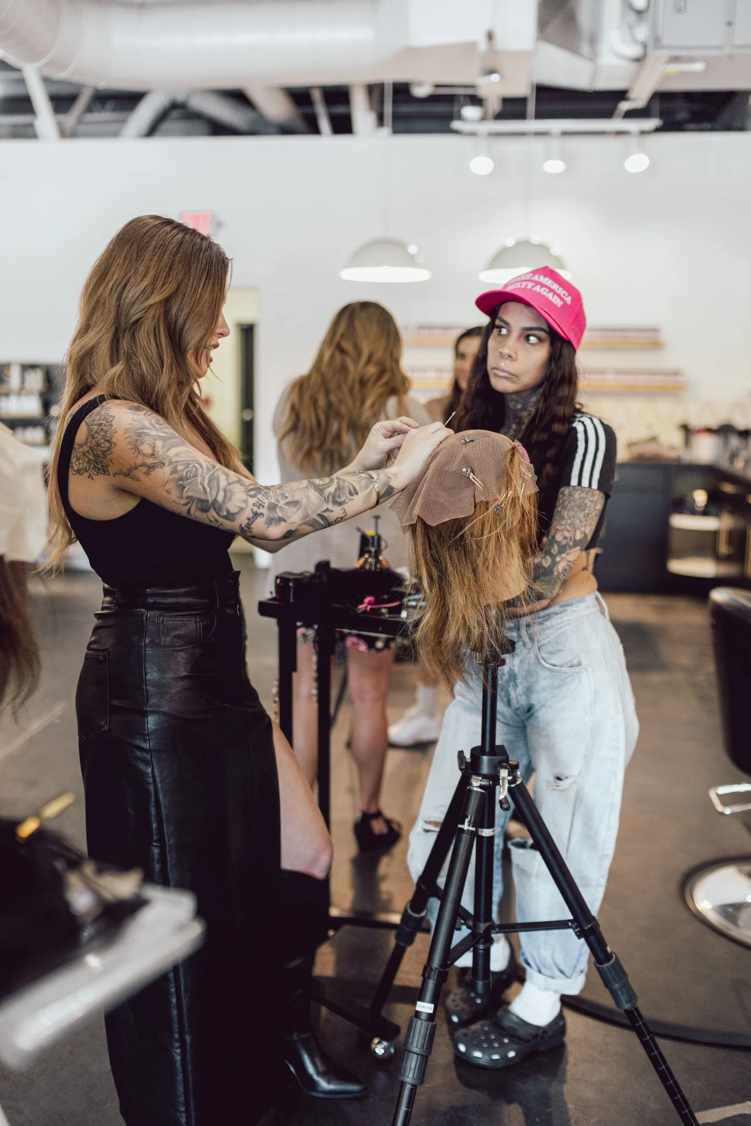 Carissa Maness securing a mesh hairline unit on a mannequin during a hands-on hair replacement demonstration