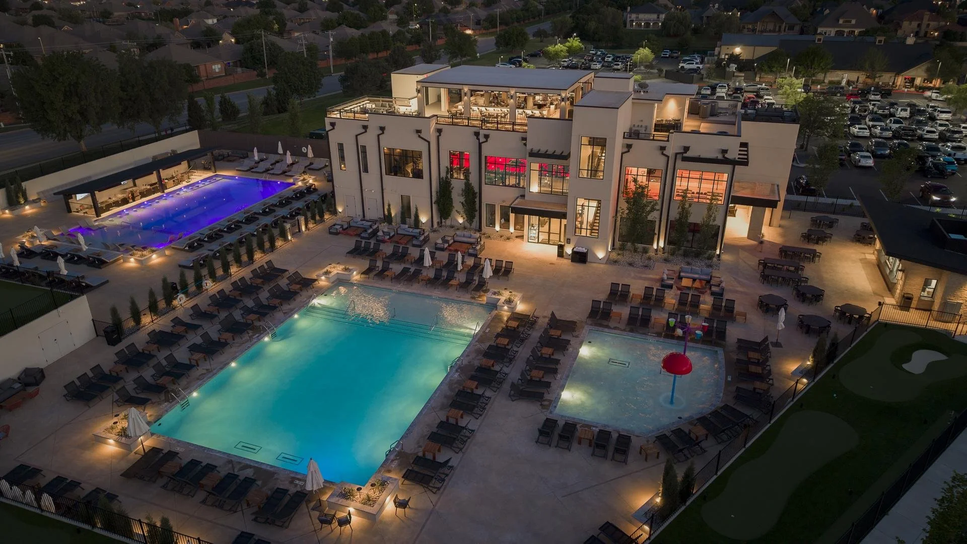 Aerial view of Rose Creek Country Club's pool complex and clubhouse at dusk, Edmond, Oklahoma