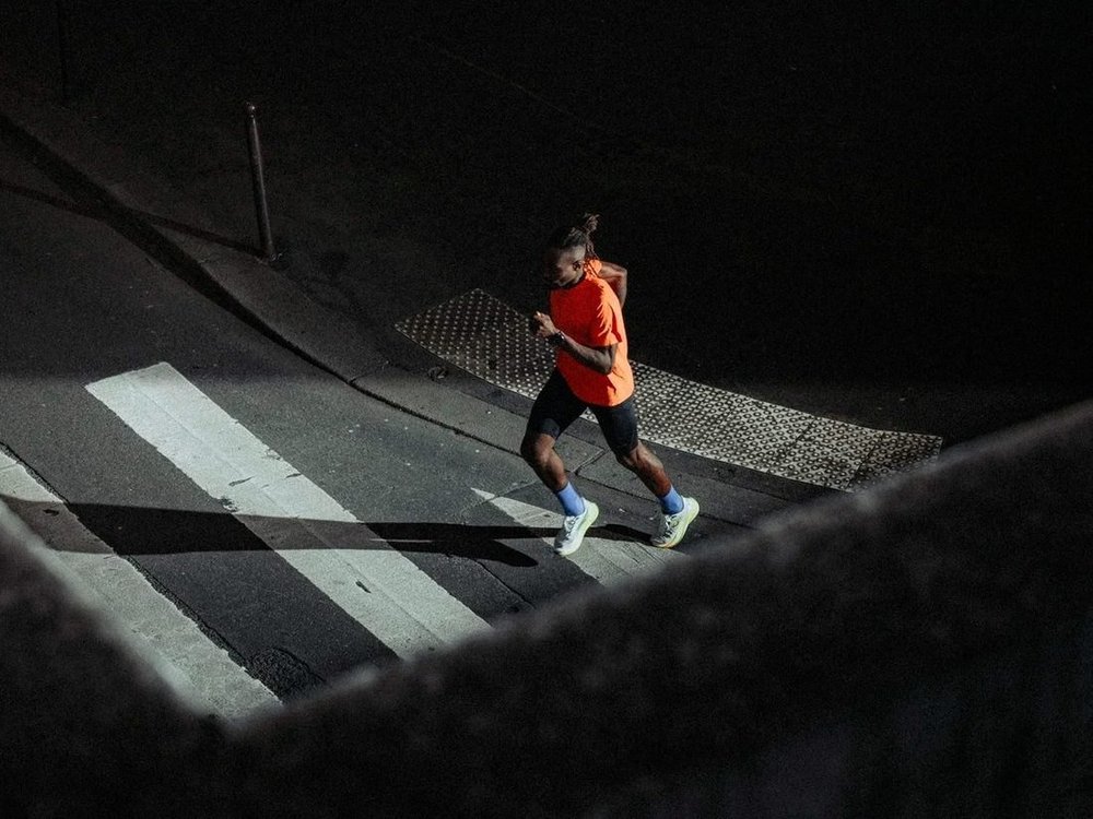 Coureur HOKA de nuit dans une rue de Paris, campagne Mach 7