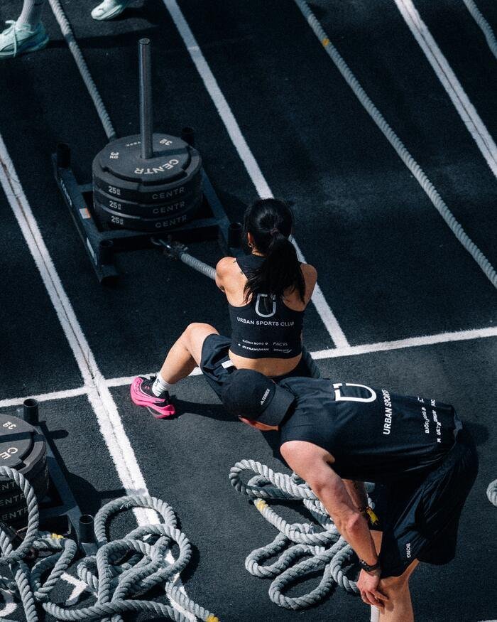 Athlète poussant un traîneau sur une compétition Hyrox, photographie fitness