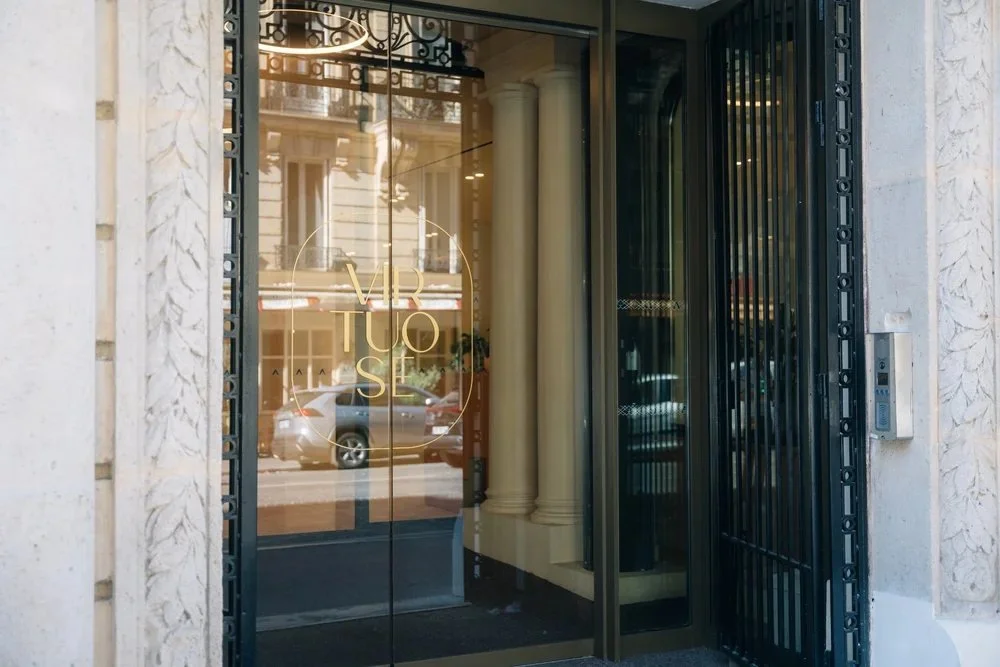 Lettrage doré Virtuose sur la porte vitrée de l'immeuble, posé par DecoAder