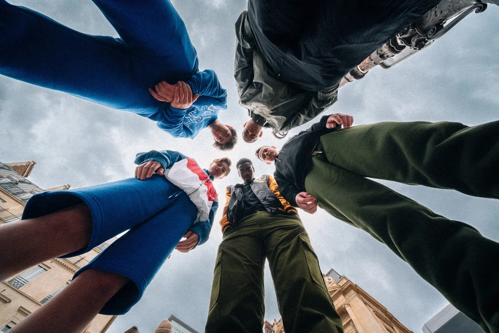 Groupe de jeunes en tenues Twins for Peace photographié en contre-plongée, shooting LUSANT Prod.