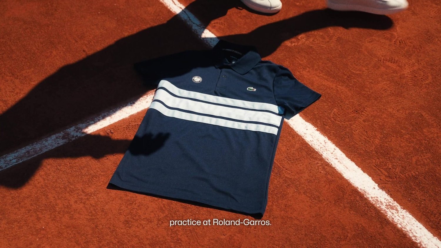 Polo Lacoste Back On Court posé sur la terre battue de Roland-Garros, mise en scène produit