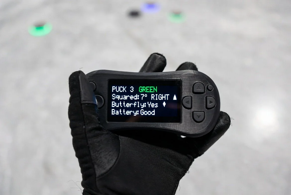 Coach holding remote with live OLED feedback display