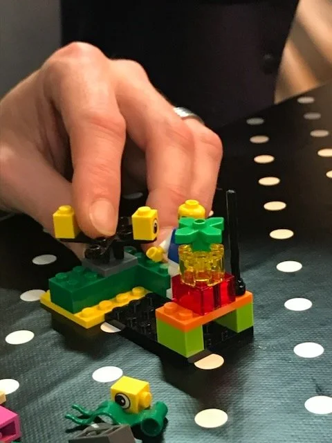 A participant explaining their LEGO model to the team