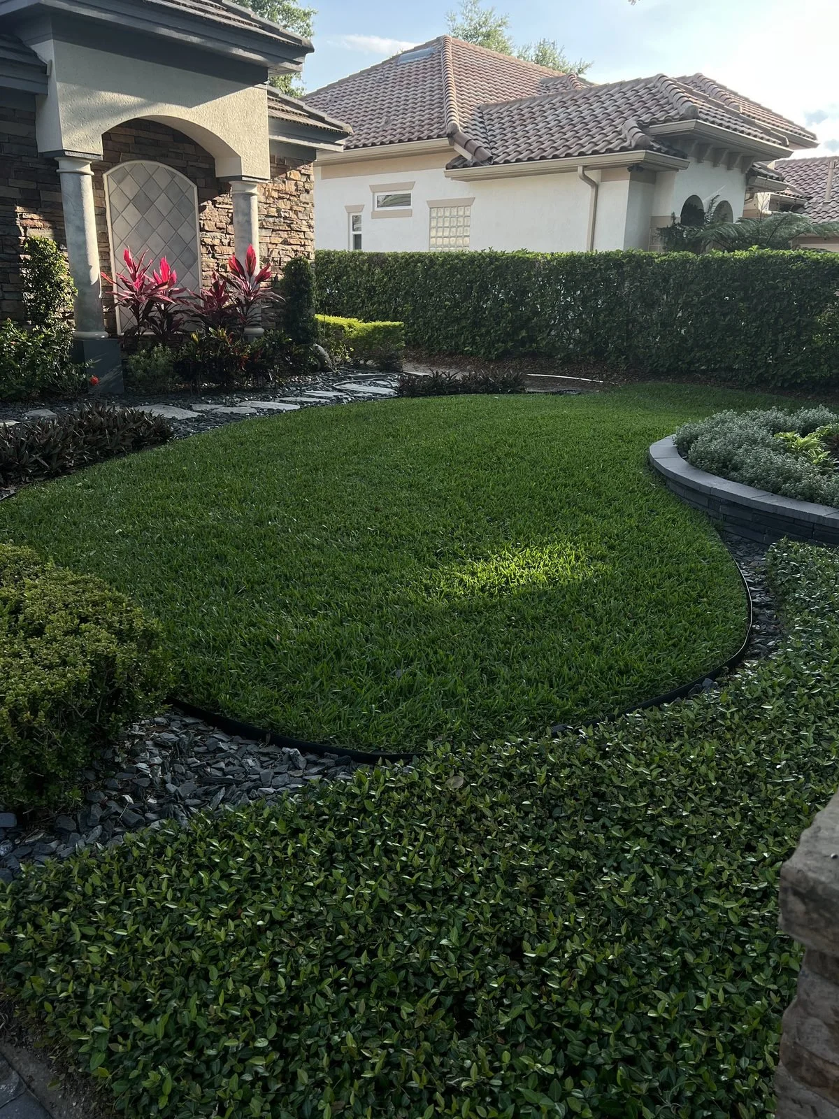 Estate lawn care and landscape design at an Oviedo FL property with manicured turf and tropical plantings