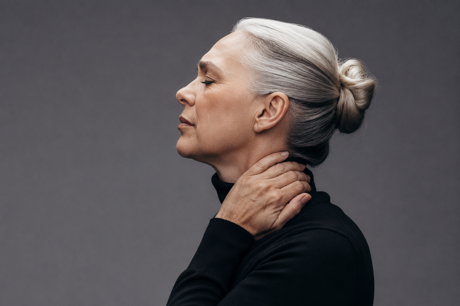 Woman resting with her hand at her neck, representing pain and physical tension