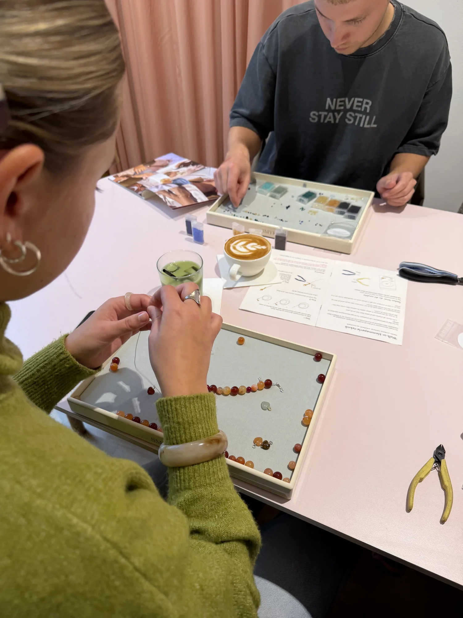 Gæster laver armbånd ved bordet hos SMYKBAR