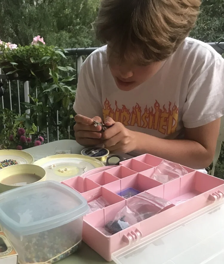 Noah macht Schmuck am Esstisch