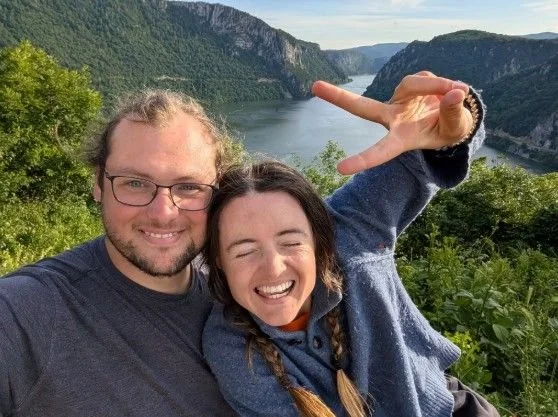 Skizzi and her riding partner smiling in a selfie high above a dramatic river gorge on the Danube