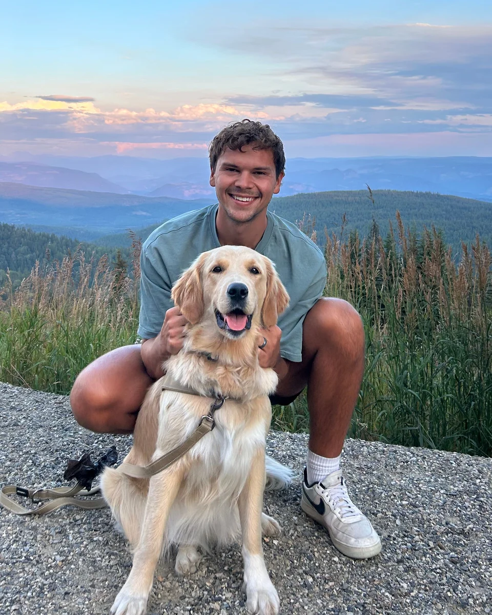 Josiah Falk with a dog on a mountain outing