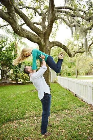 Eric Hardek lifting Tiffany Hardek playfully outdoors, husband and wife insurance team serving Winter Garden, Minneola, Windermere, and Clermont