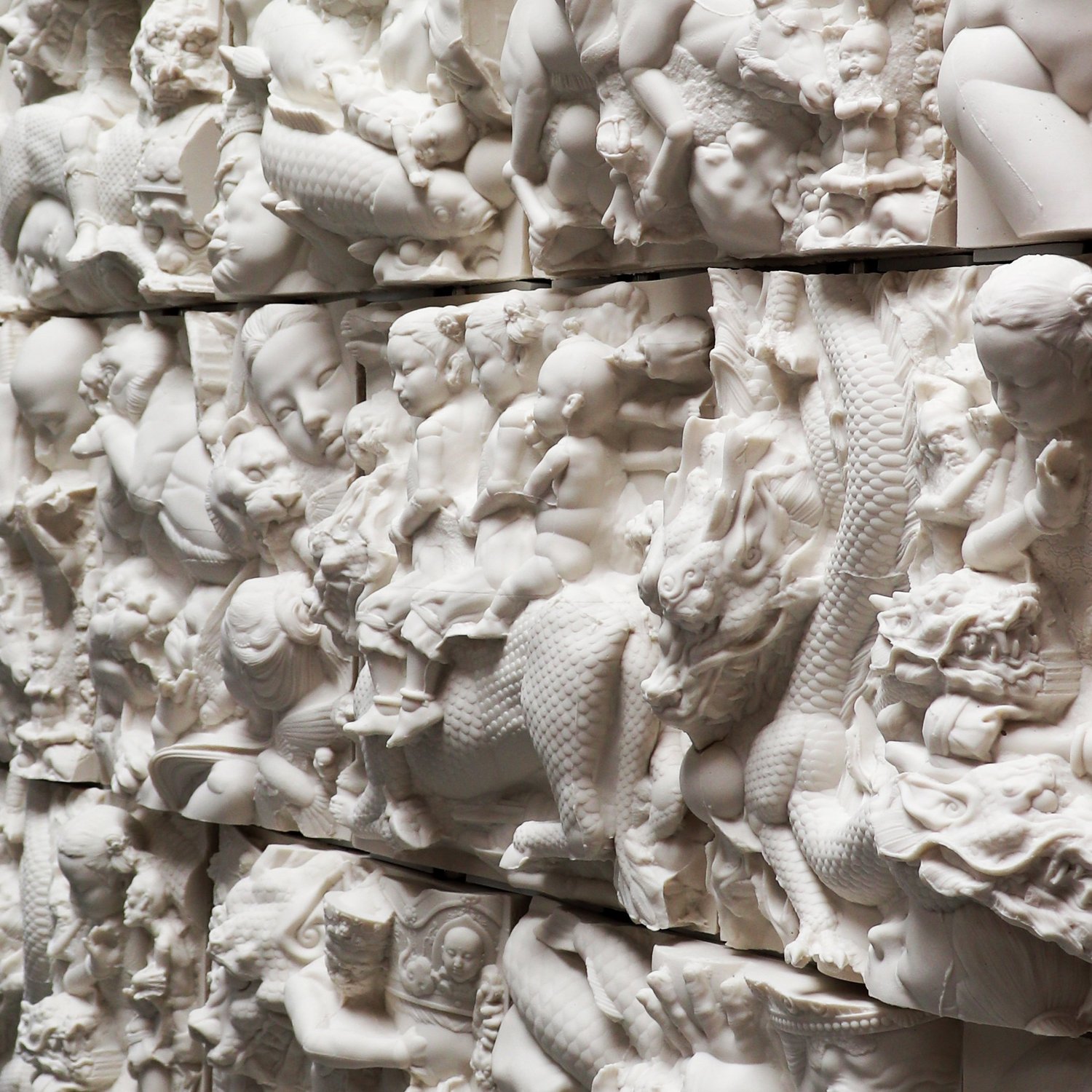 Square ceramic relief units arranged in rows, with human and animal forms crossing their surfaces.