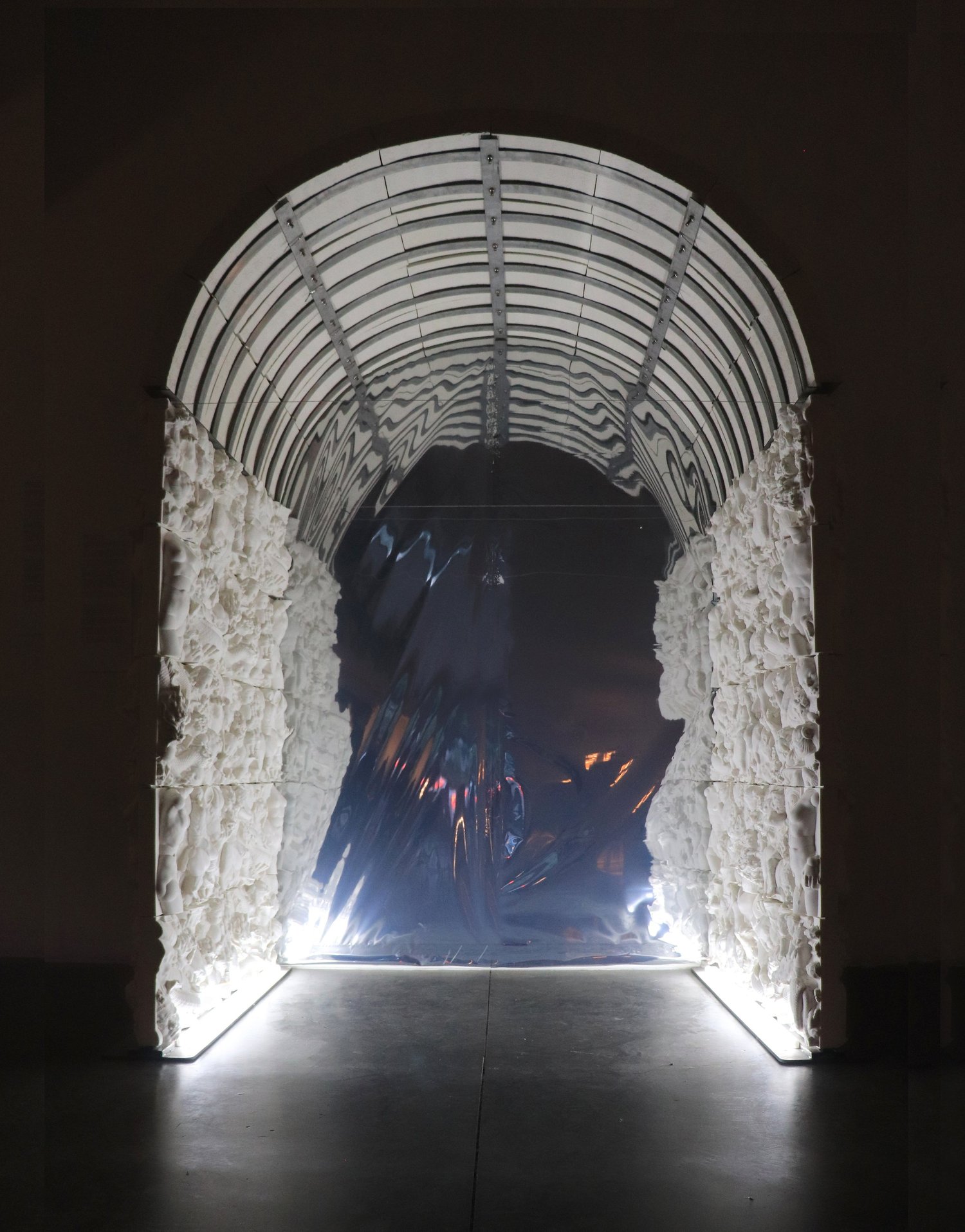 Beneath the Mountain: arched ceramic installation with illuminated relief walls