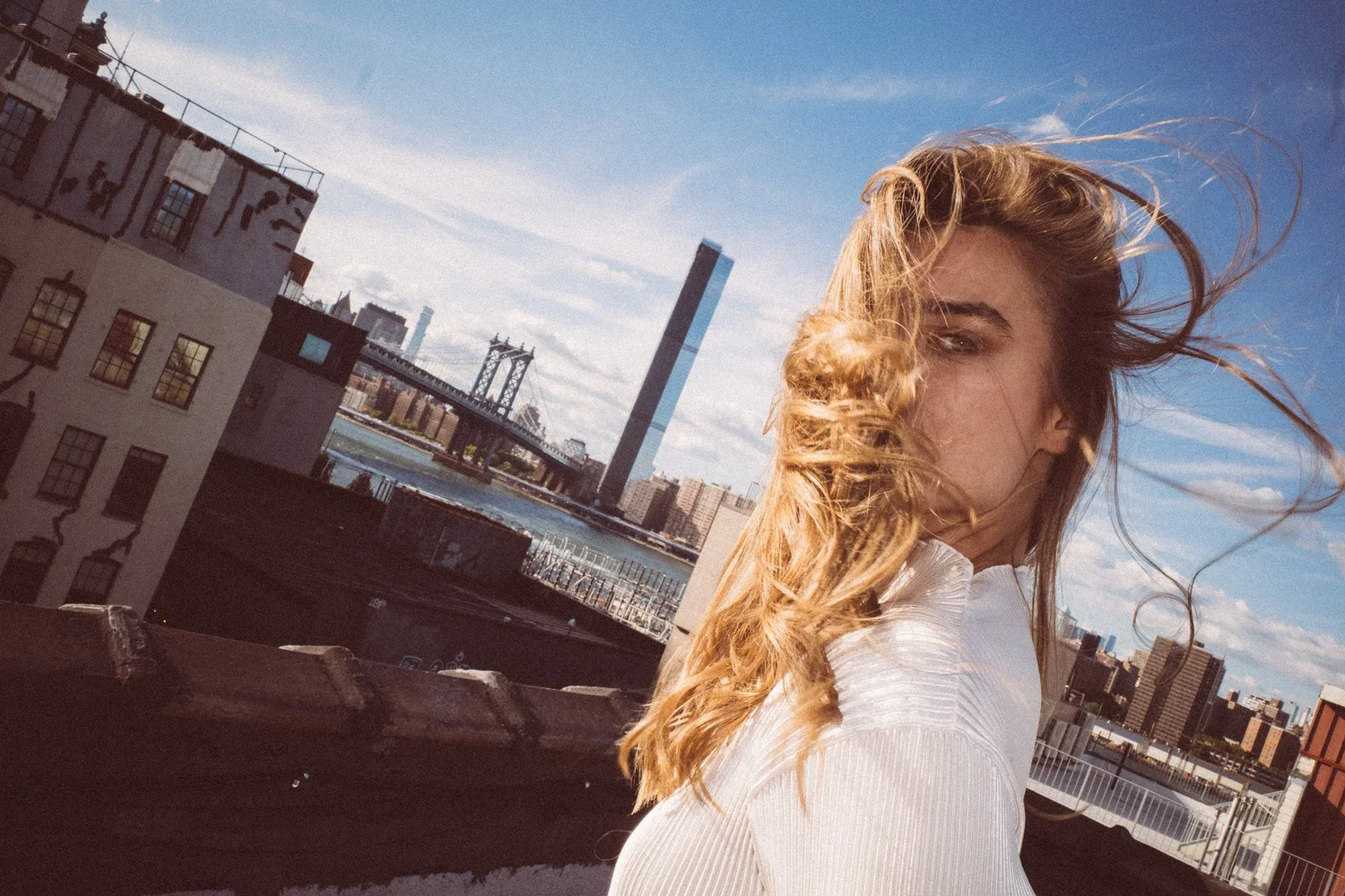 Wind lifting Cydney’s hair across her face in a tilted rooftop portrait
