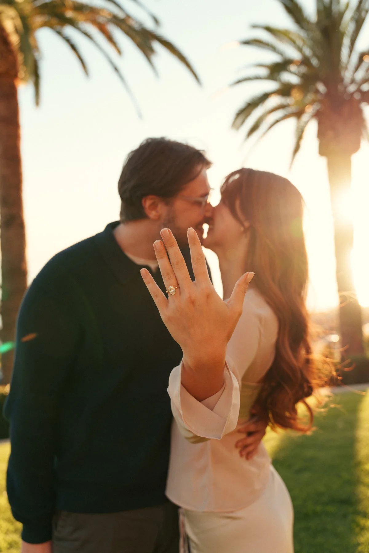 Hannah and Garrett together beneath palms in warm backlight