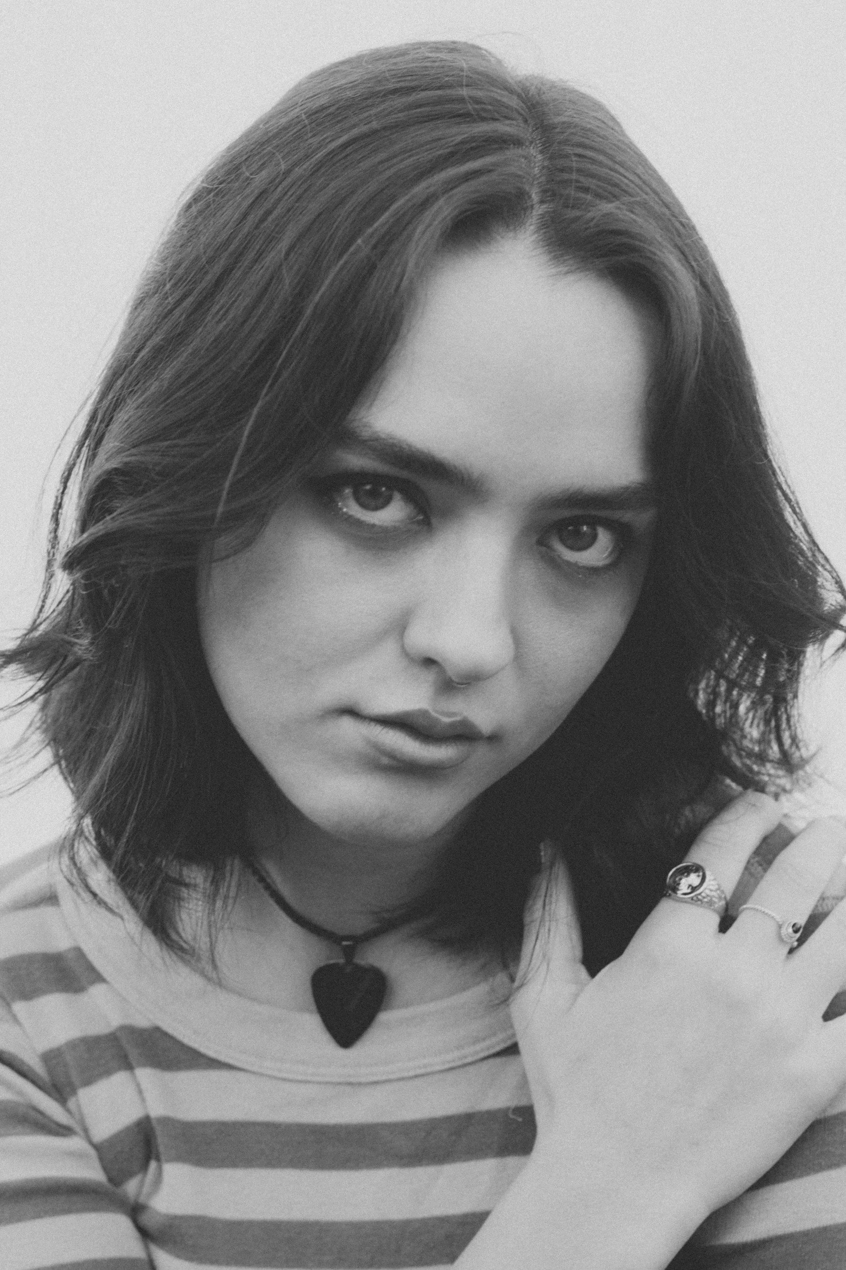Black-and-white close portrait of Jenna Doe with one hand on her shoulder.