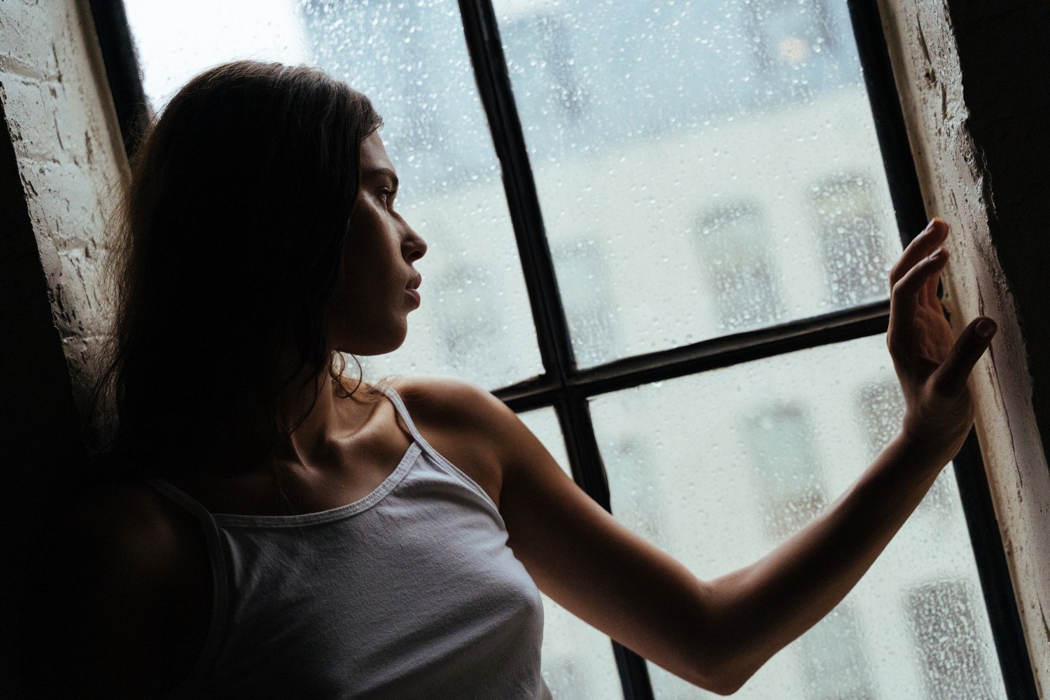 Tara in profile touching a rain-speckled window
