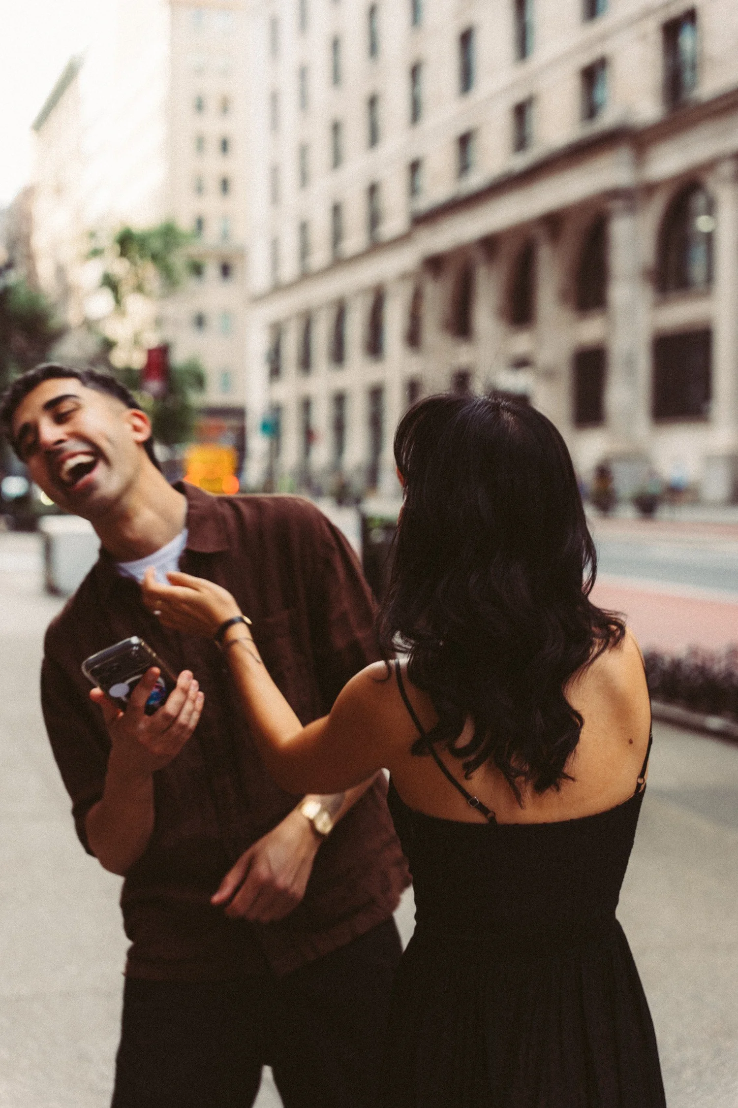 Sophia and Mike laughing together on a city sidewalk