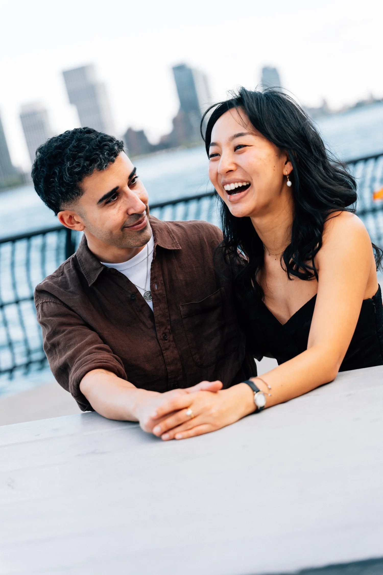 Mike and Sophia laughing together beside the waterfront