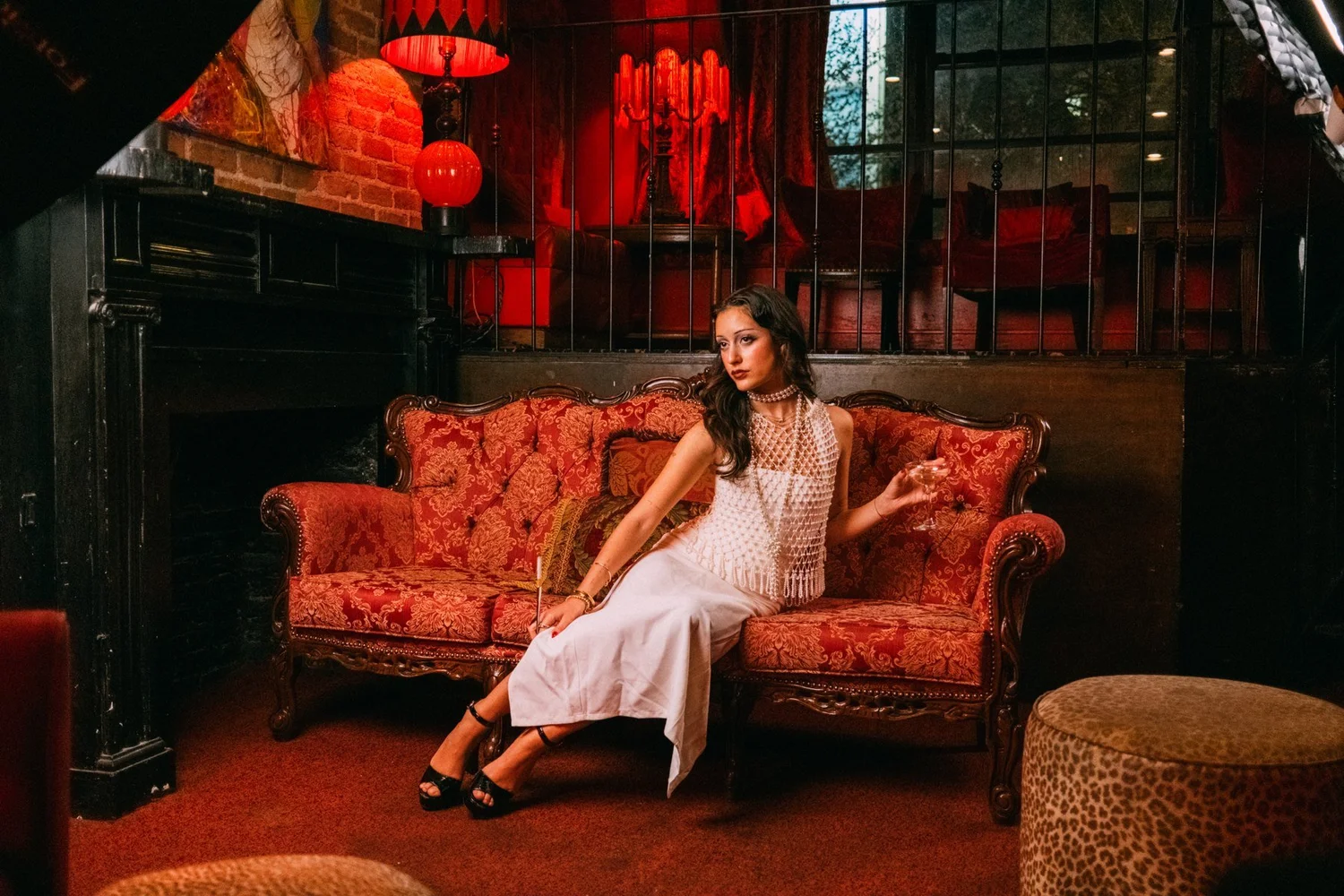 Eden seated on a patterned couch beneath red lanterns