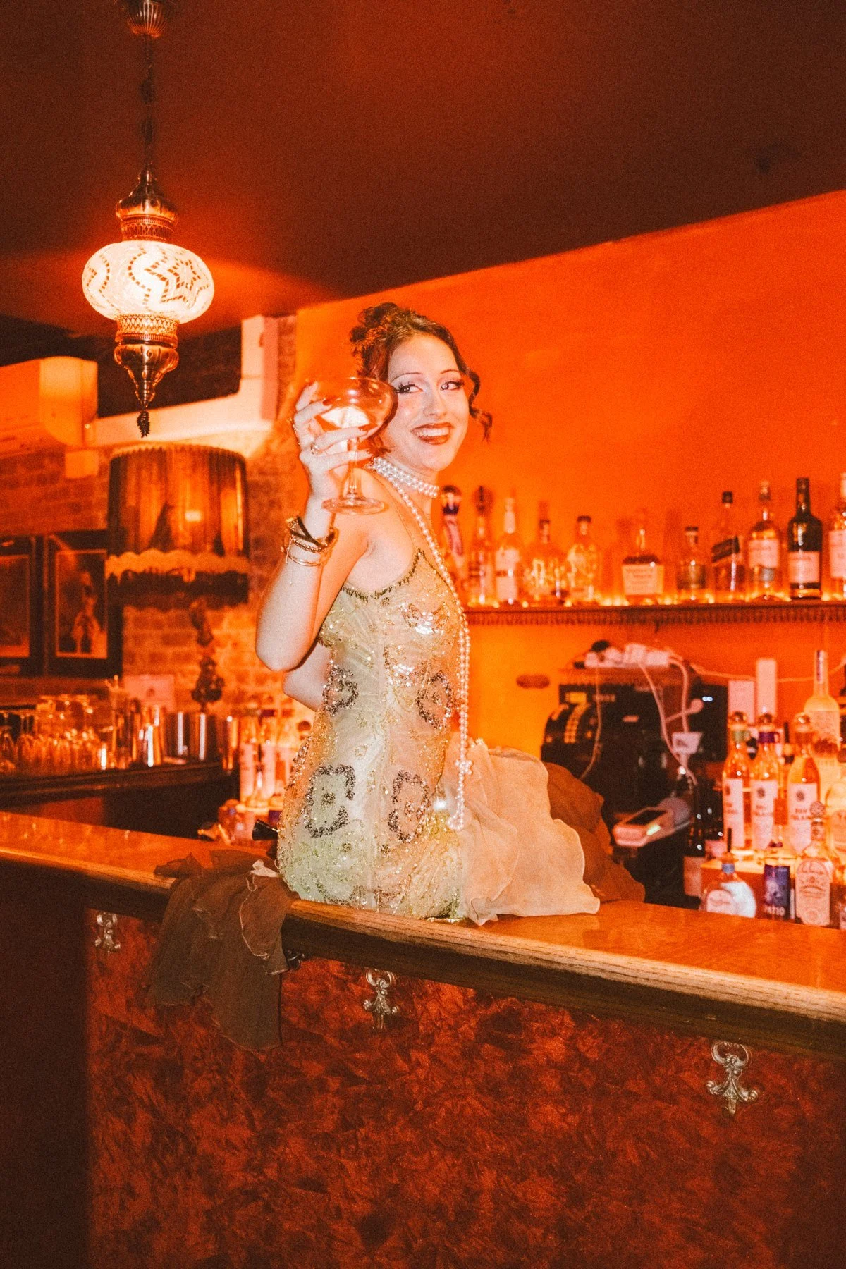 Eden at the bar in a green embellished outfit