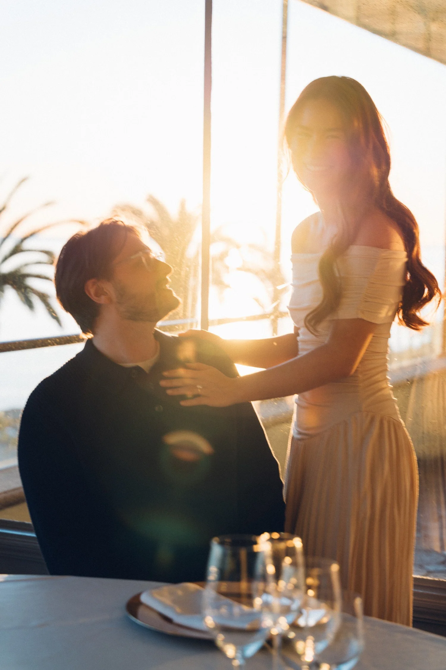 Hannah and Garrett together beside a bright window and table