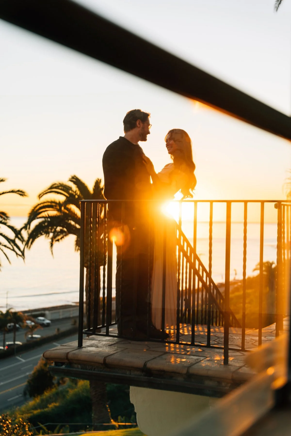 Hannah and Garrett silhouetted against the low sun on a balcony