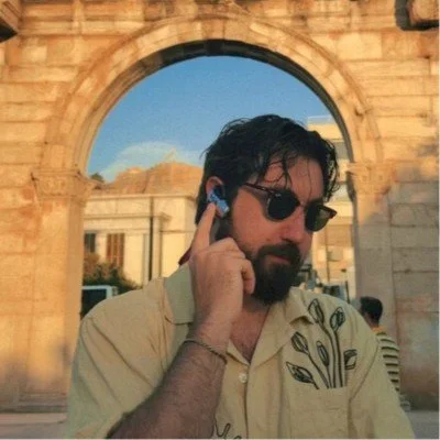 Nick Greenawalt wearing sunglasses beneath a stone arch