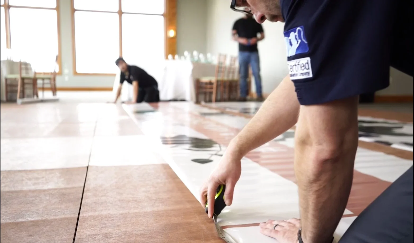 Installer carefully trimming a floor graphic