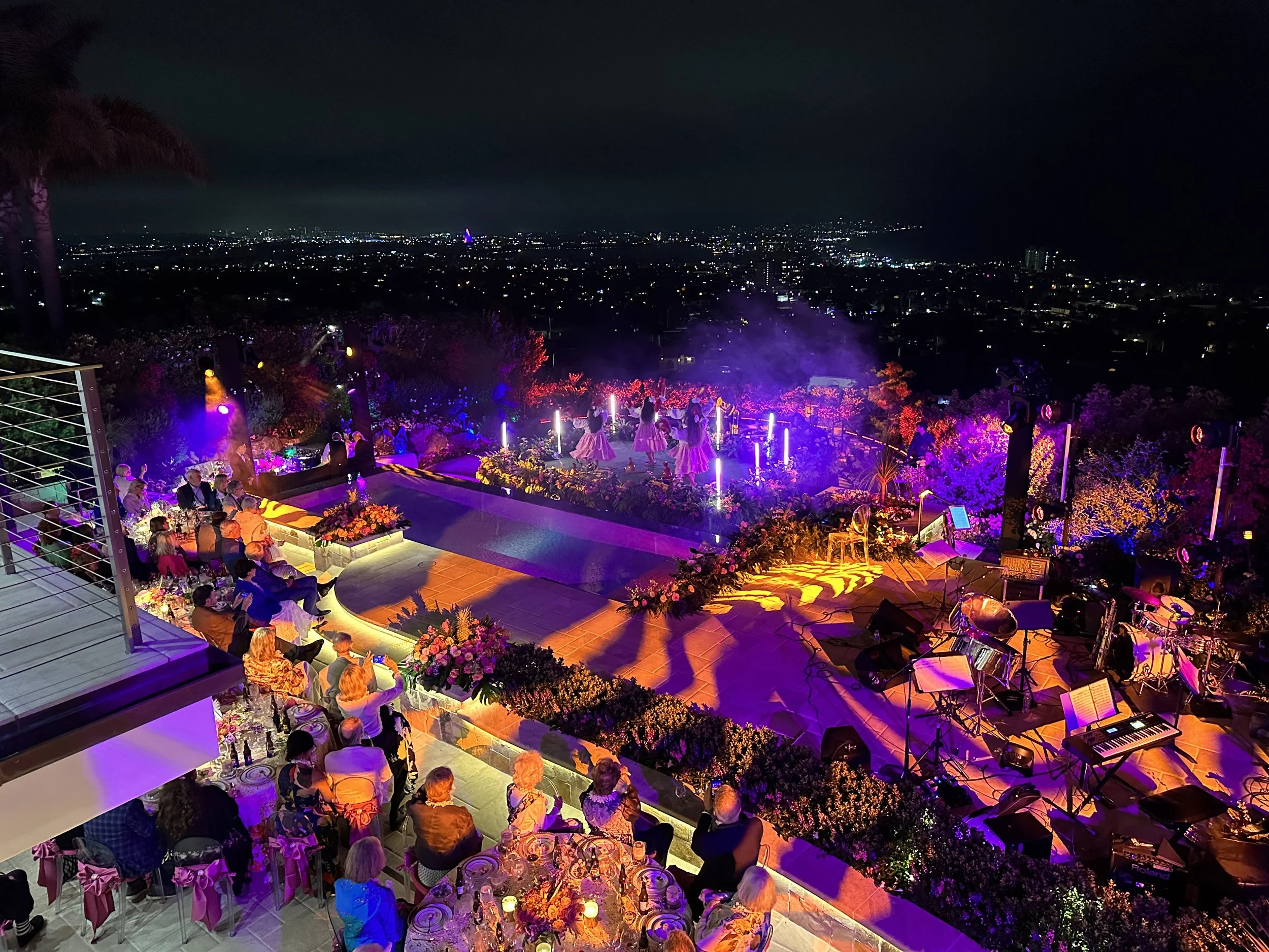 Purple LED tube lighting at hilltop event with city views
