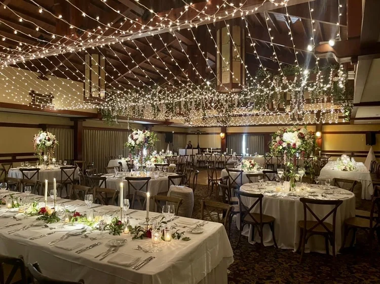 Banquet tables under a full twinkle-light ceiling at The Lodge at Torrey Pines wedding reception