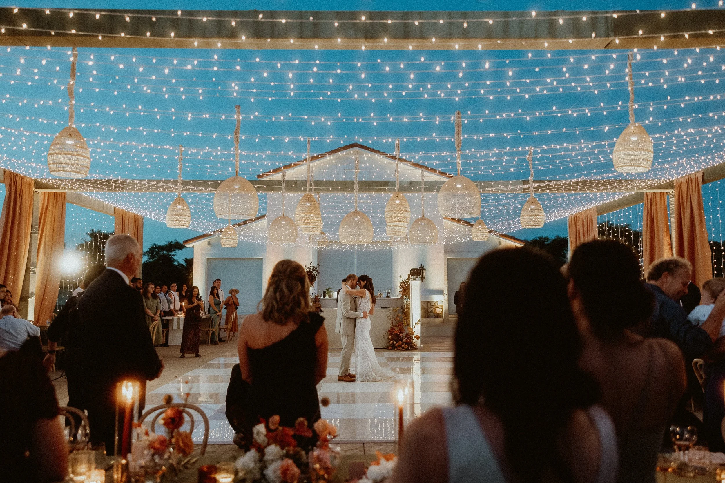 Overhead string lights at outdoor wedding celebration